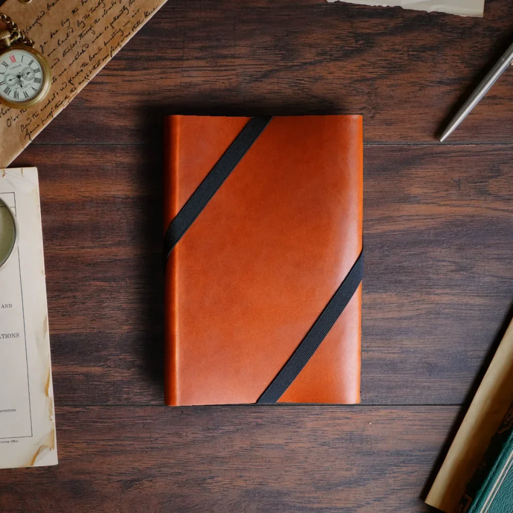 A leather everbook in light tan leather with black elastic band, the ultimate productivity tool