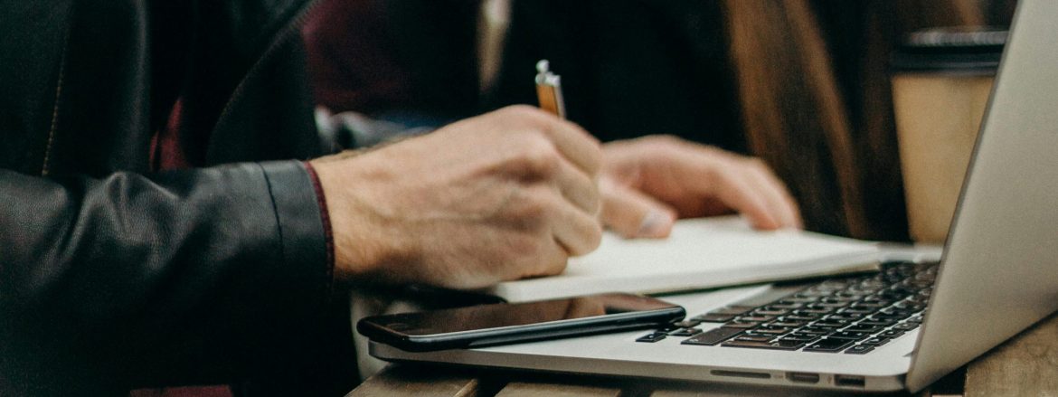 freelancer working at a table with his laptop and Everbook for great freelance analog productivity