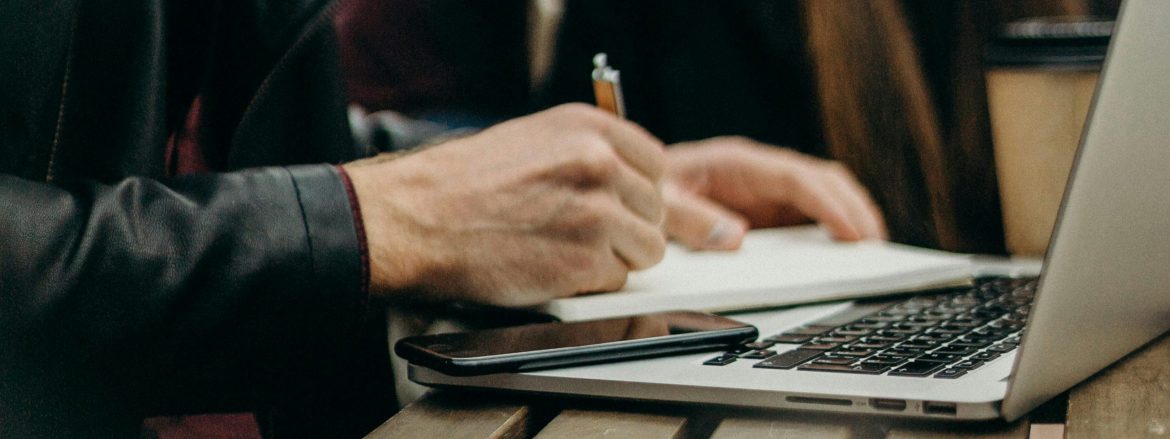 freelancer working at a table with his laptop and Everbook for great freelance analog productivity