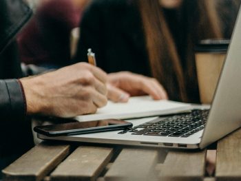 freelancer working at a table with his laptop and Everbook for great freelance analog productivity